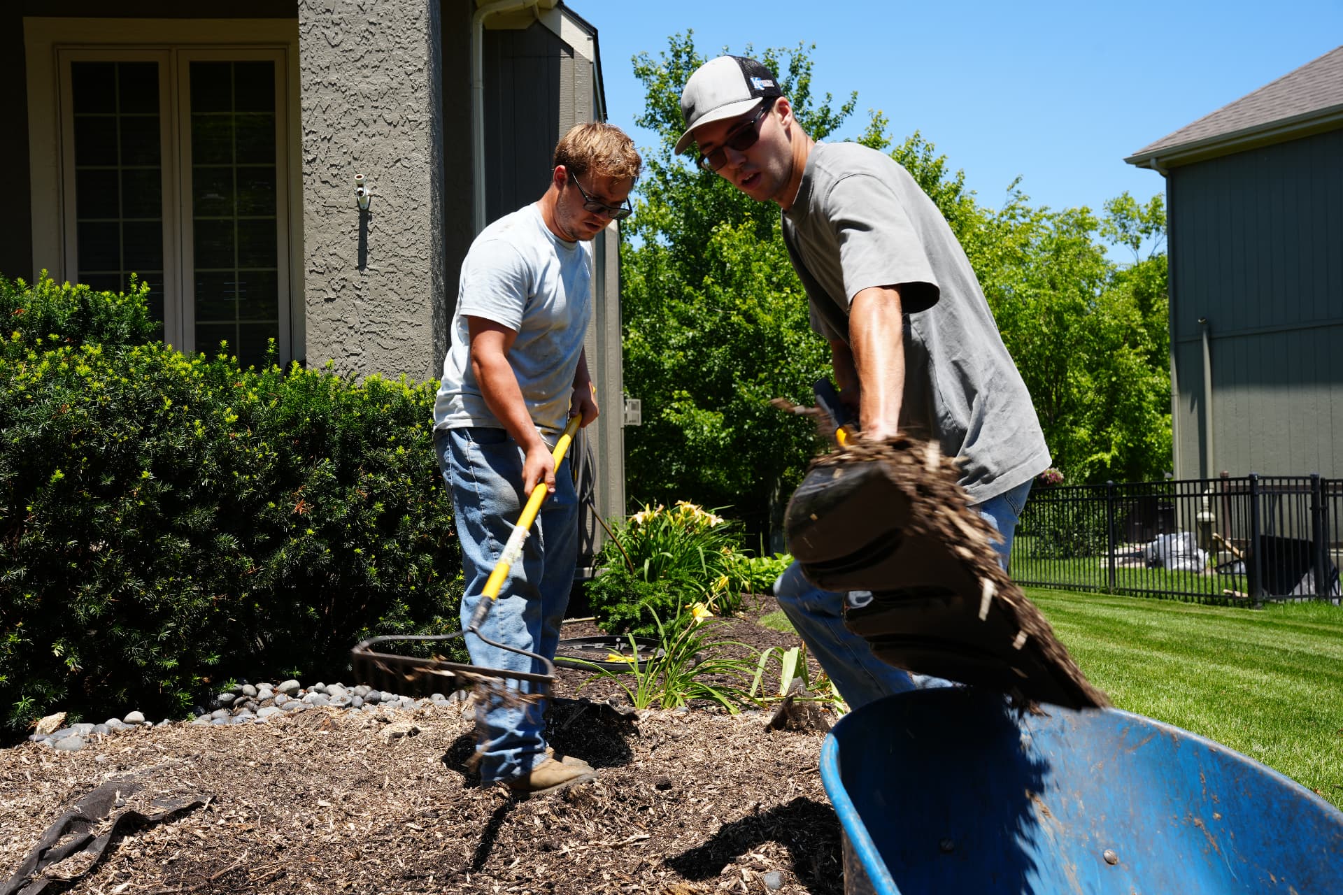 Bluestem crew spreading mulch in a landscape bed